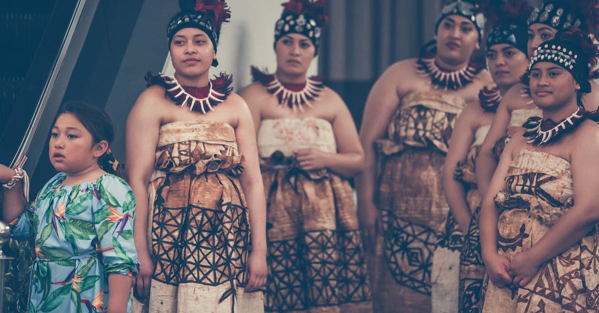 German National Visa - Internship or guest researcher? - Group of ethnic women wearing authentic costumes and traditional headdresses with necklaces standing in room while watching wedding ceremony during holiday celebration