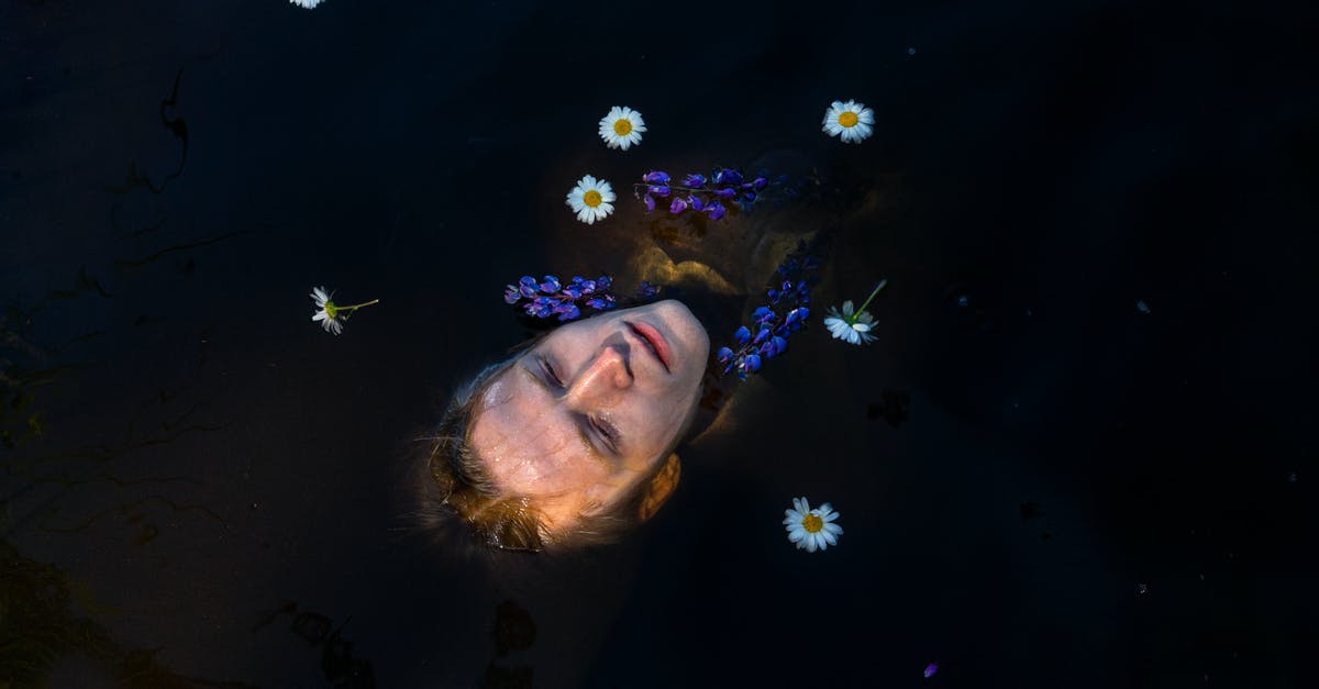 Germany, Thuringia, Inselsberg visible from Bavaria, Coburg? - Head of man lying on water with flowers