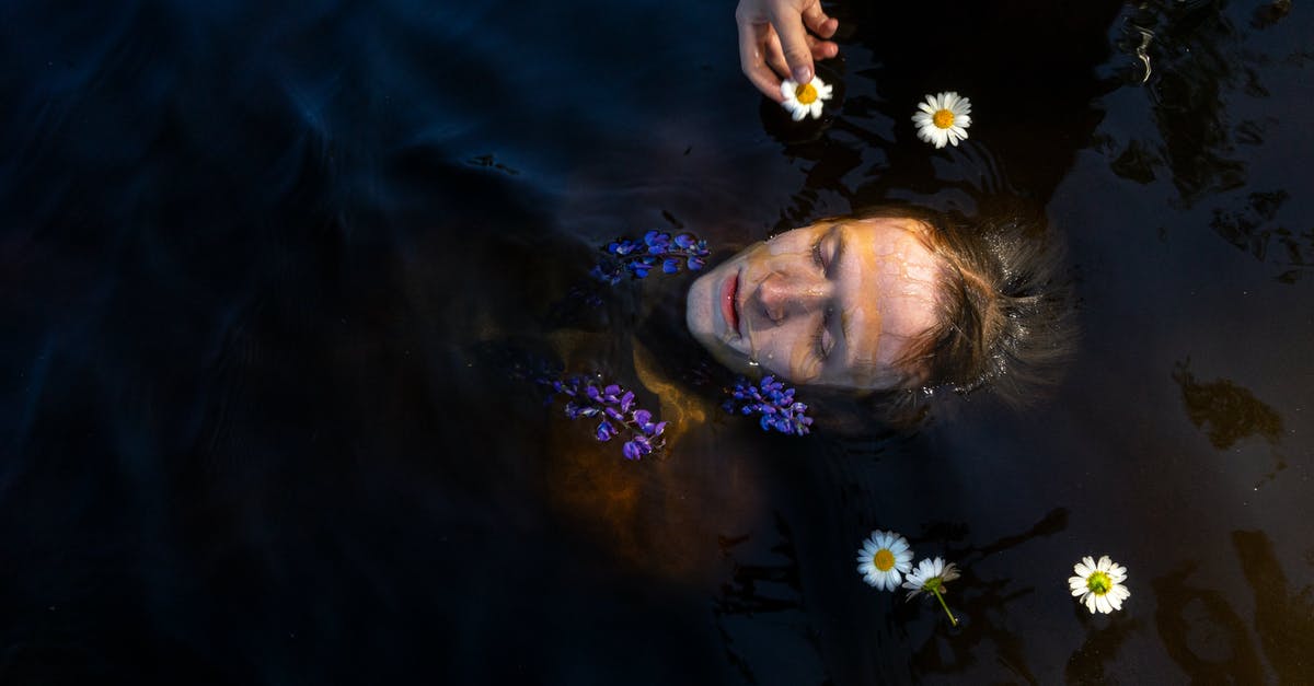 Germany, Thuringia, Inselsberg visible from Bavaria, Coburg? - Person swimming in water with flowers