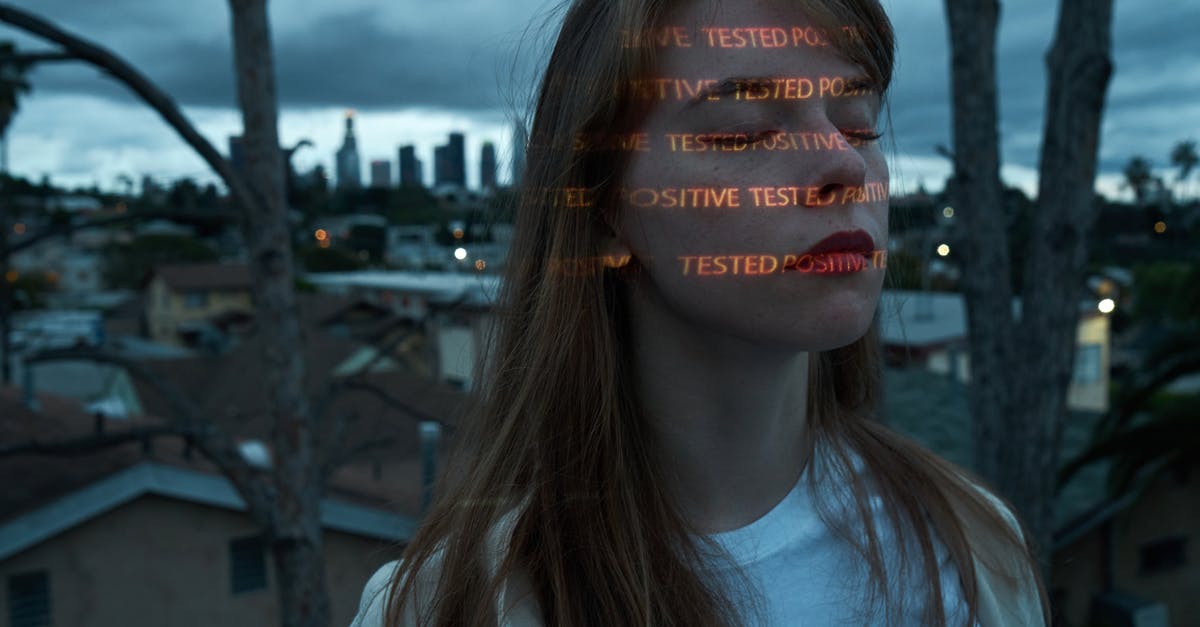 Germany: What happens if you test Covid positive on arrival - Calm woman with Positive Tested words on face on roof against cityscape