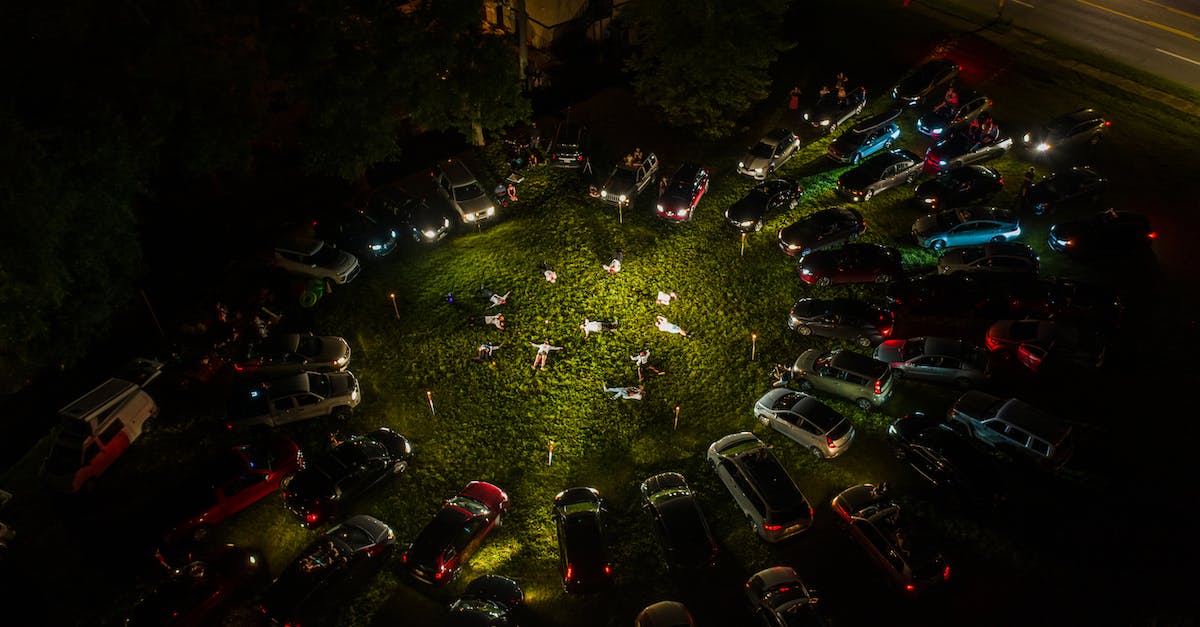 Getting 3rd party car insurance for Iran from Pakistan - Unrecognizable people lying on grass near parked cars in evening