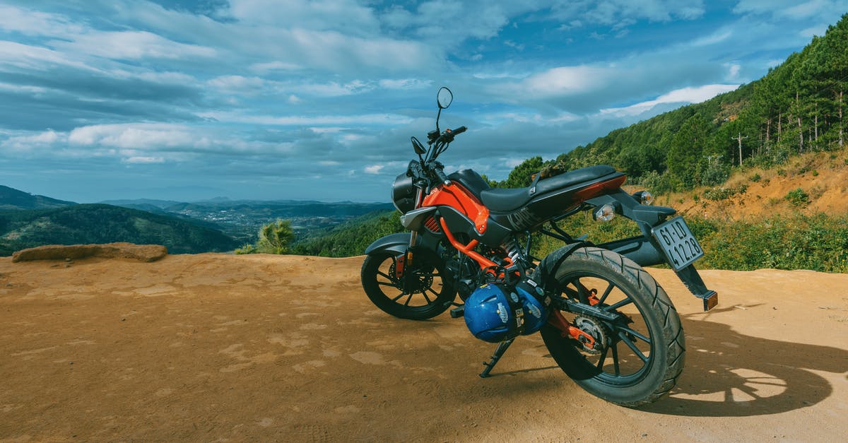 Getting a motorcycle license in France - Photography of Orange and Black Sports Motorcycle Near a Cliff