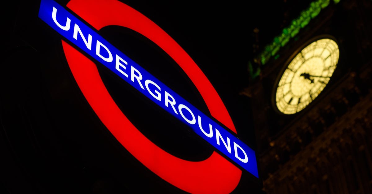 Getting around in London by metro [duplicate] - Underground Signage Near Clock Tower during Night