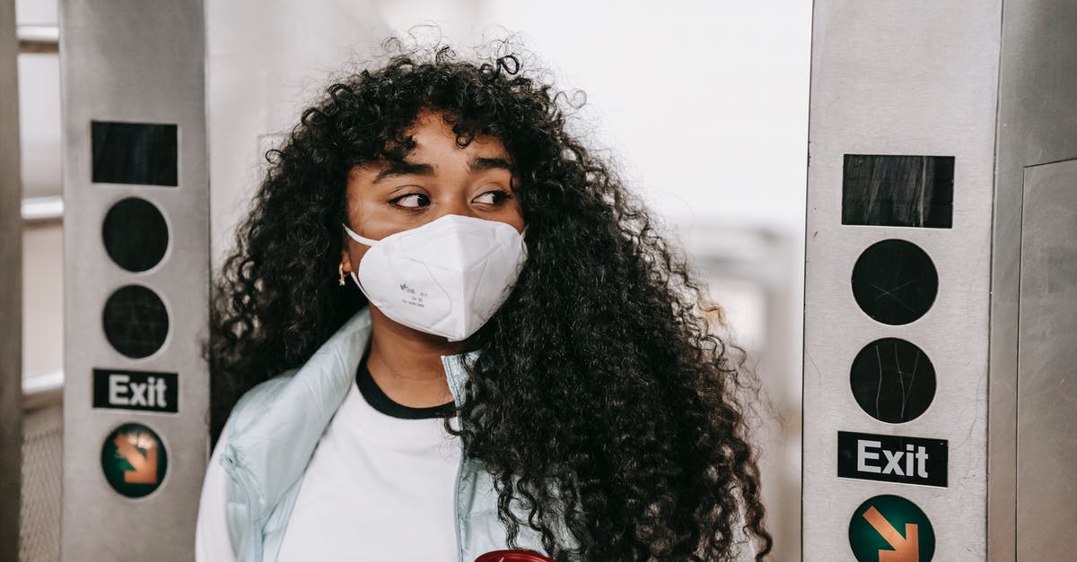 Getting Boarding Pass from inside Transit area in Dubai Terminal 1 - Black woman in mask passing through underground turnstile