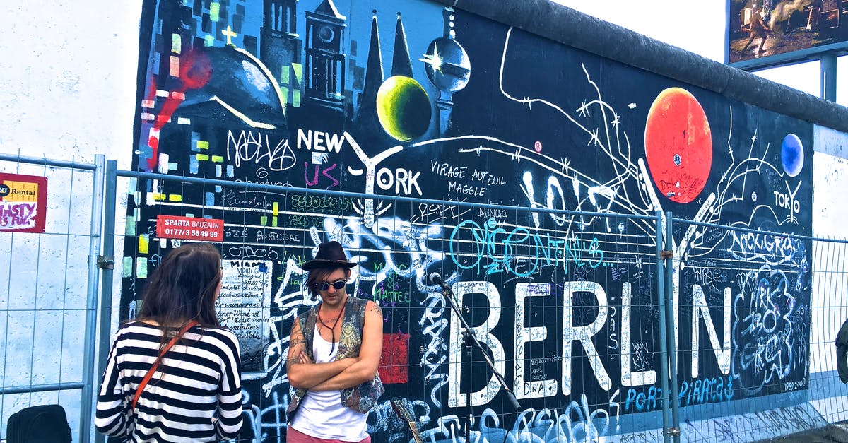 Getting from Berlin Tegel Airport to downtown - Man Wearing Black Waistcoat and White Tank Tops Standing Near a Mural