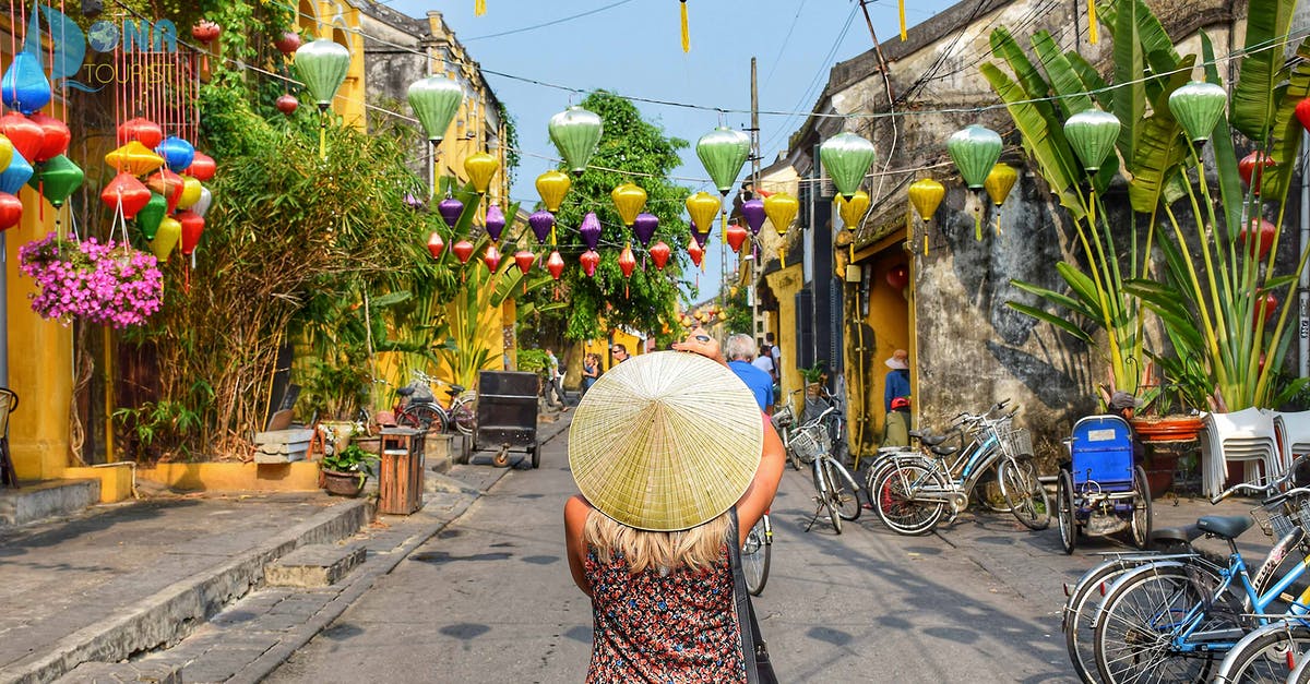 Getting from Laos to Hoi An, Vietnam - Woman Wearing Straw Hat In The Middle Of Road