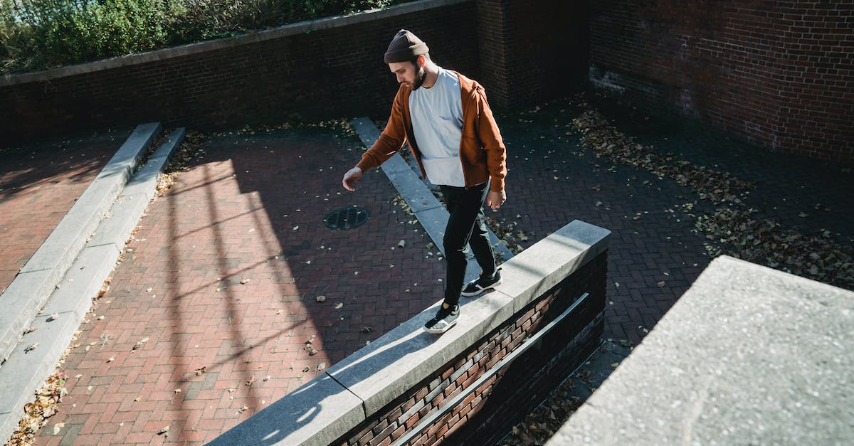 Getting from Victoria Falls airport to town - Young man walking on brick barrier top