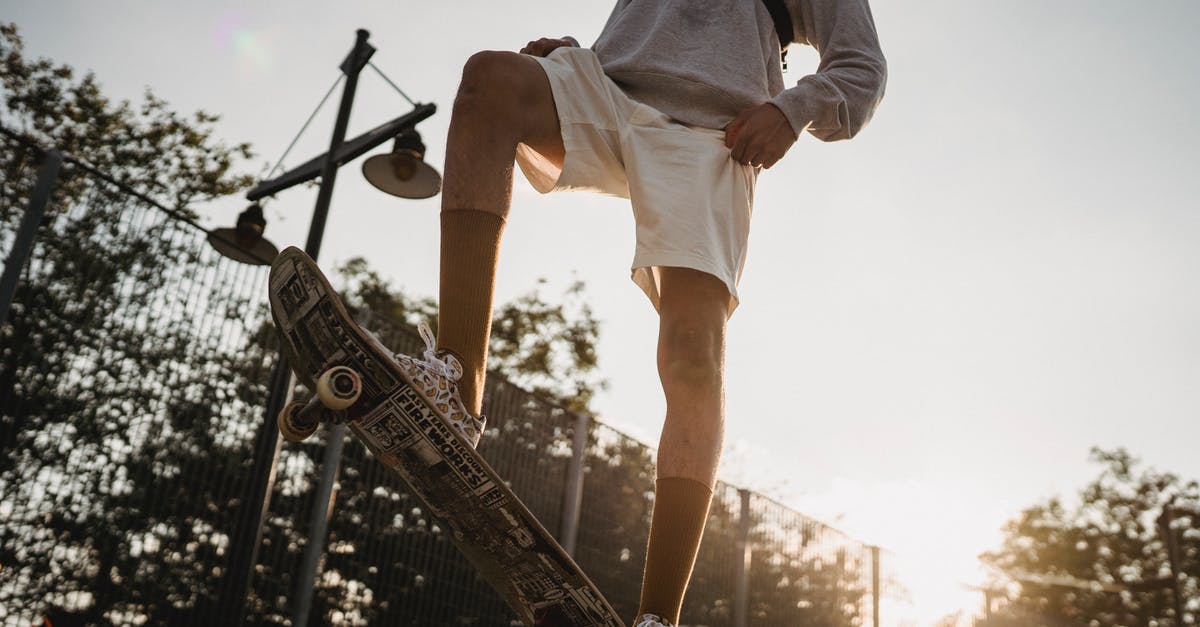 Getting from Victoria Falls airport to town - Crop sportsman preparing for skateboarding on skate ramp at sunset