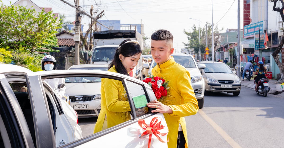 Getting to the Casablanca wineries from Valparaiso without a car - Man in Yellow Long Sleeve Shirt Holding Red and Yellow Flag Standing Beside White Car during