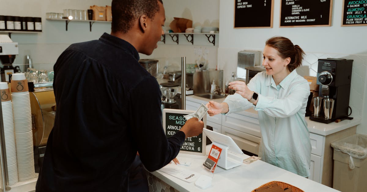 Getting USD cash in Munich on UK cards - A Woman Receiving Money from the Customer