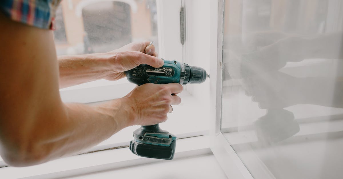 Ghana Passport renewal - Workman screwing window frame during housework