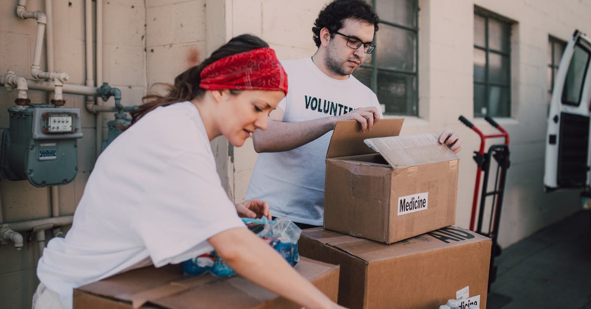 Giving First Aid in the USA - A Man and a Woman Packing Relief Goods in Boxes