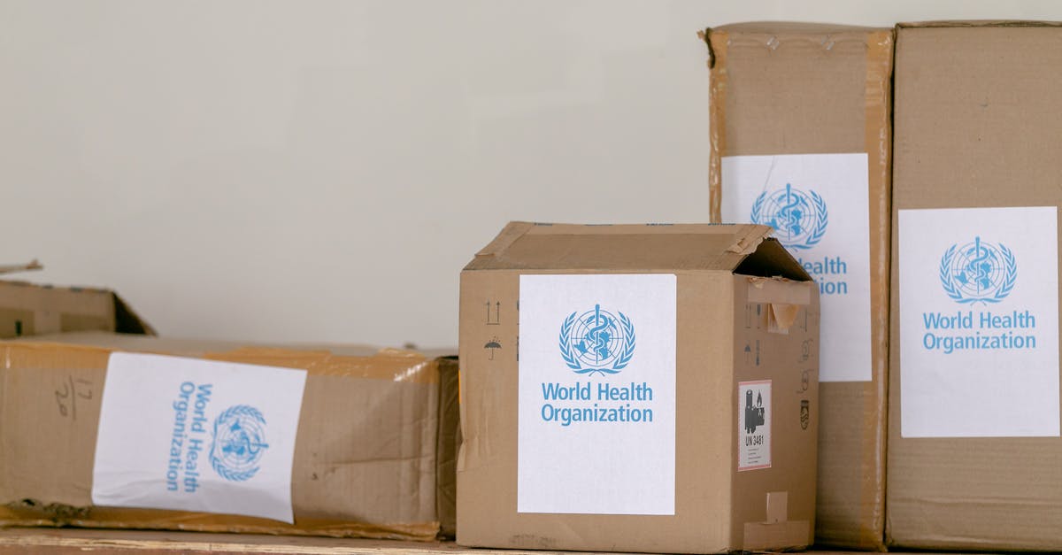 Global Blue with D visa (Netherlands): possible? - Blue emblem sticker of World Health Organization on carton boxes heaped on table
