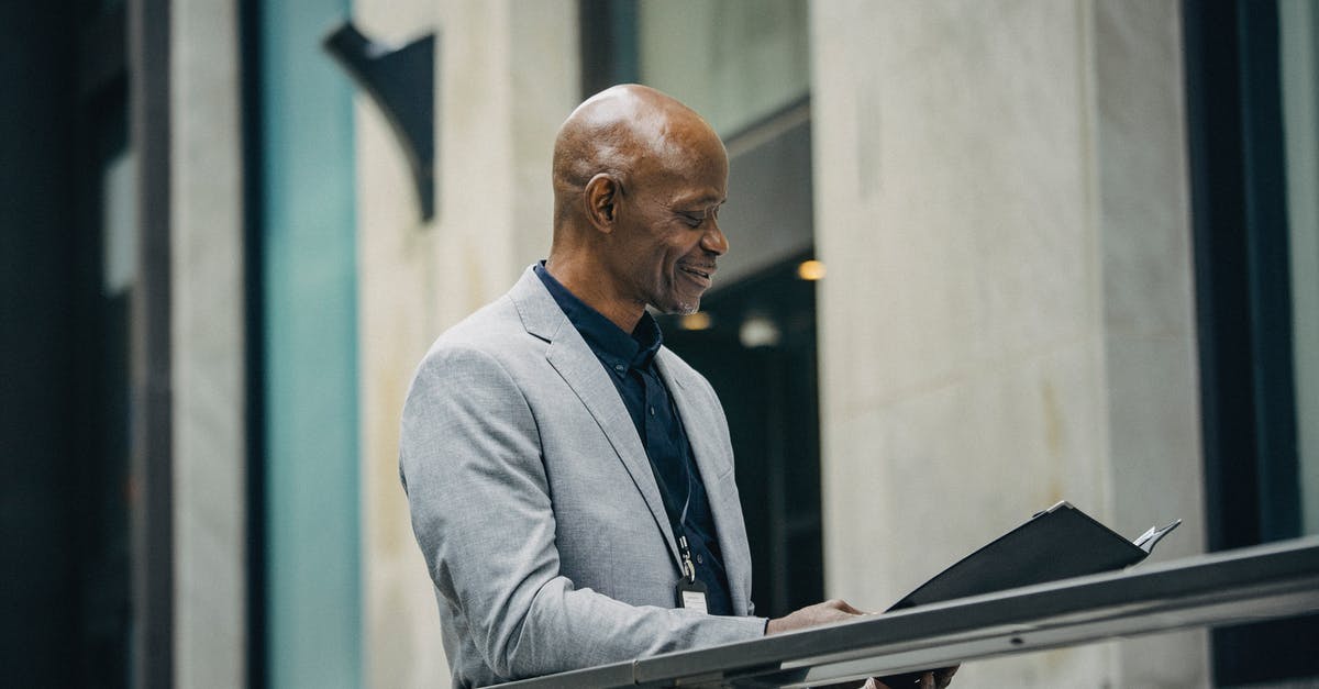 go to check-in for visa check and boarding card - Cheerful African American manager reading documents in folder