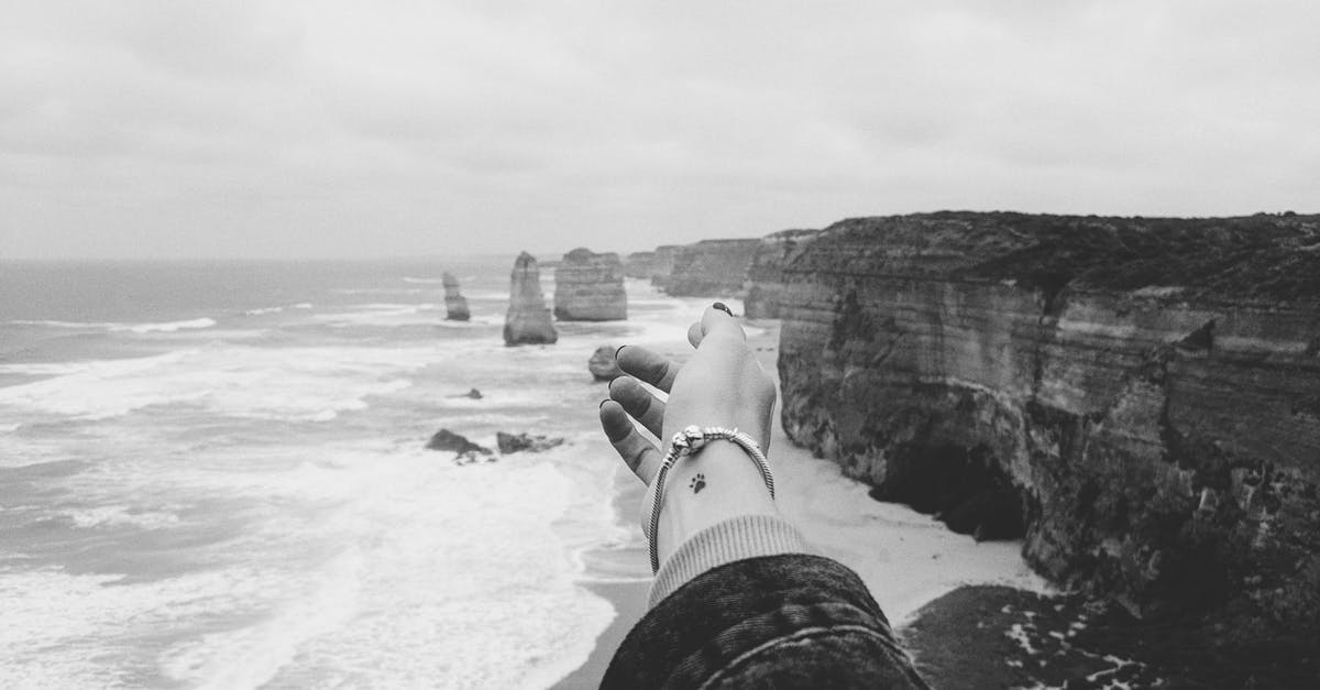 Going to Australia - hand luggage - Greyscale Photograph of Person Standing Near the Ocean