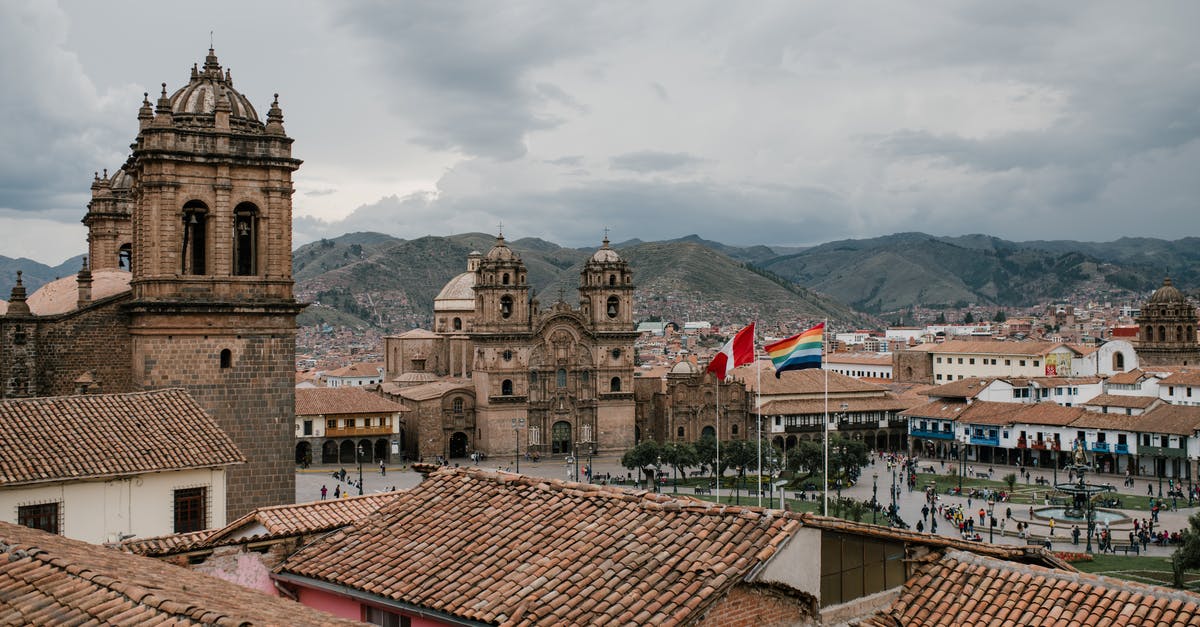 Going to Cabrillo National Monument by bus - Cityscape of medieval church and houses with old tile roof in Cusco Peru