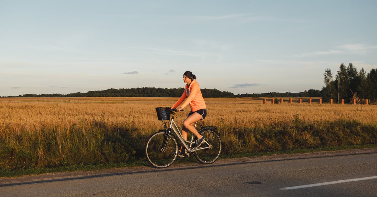 Good route for a 1-day bike trip around Amsterdam - Woman riding bicycle on road against countryside field