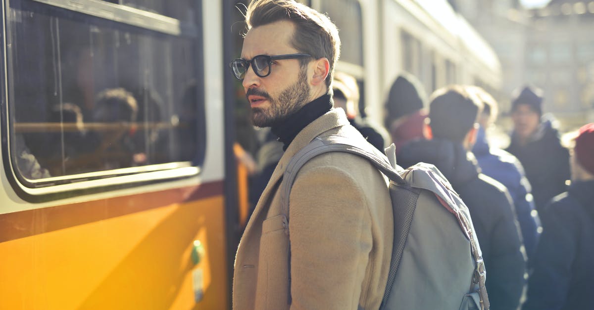 Good website for checking train options in Spain/Portugal? - Man in Brown Coat and Gray Backpack Posing for a Photo