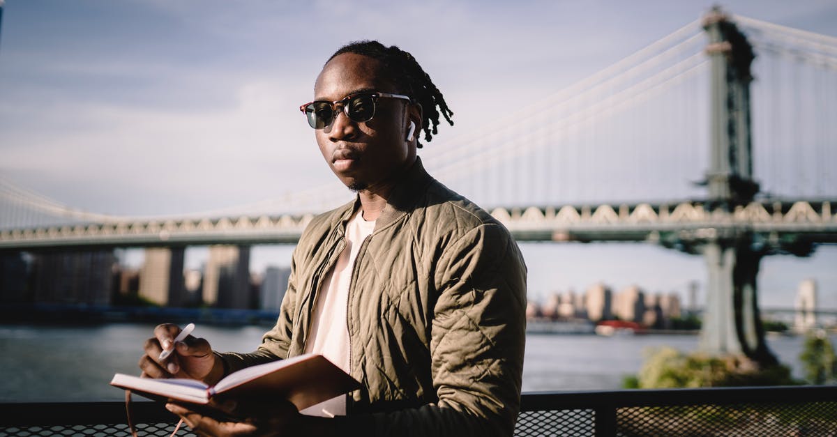 google flights, search without amound of days, trip lenth - Serious African American man planning route standing on river embankment