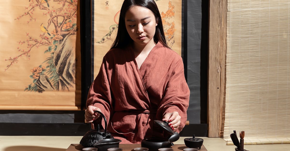 Google maps in China - Woman in Red and White Robe Holding Black Ceramic Cup