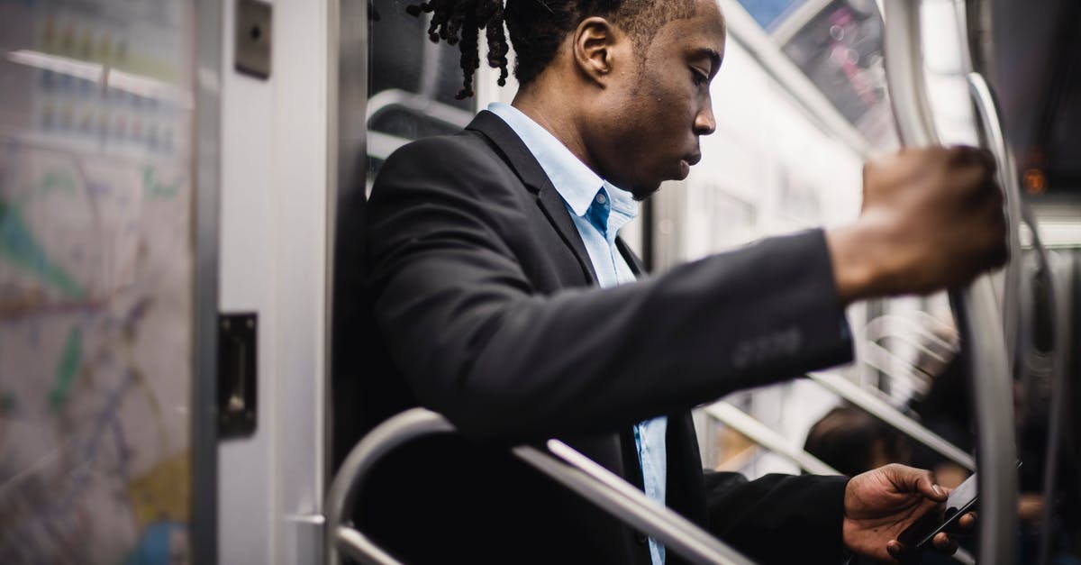 Google Maps public transport in offline mode? - Side view of crop wistful African American passenger with pigtails in formal wear using social media on cellphone while commuting to work on subway