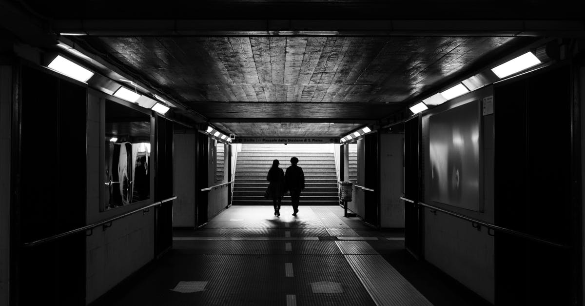 Greece Transit, Airport Exit Visa - Back view black and white of unrecognizable passengers walking to stairs in subway station