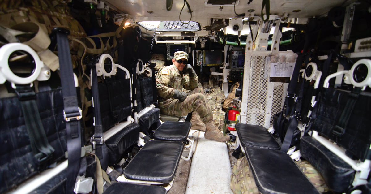 Greyhound Ticket Change $20 Fee for Military Personnel - Man in Soldier Suit Sitting in Black Leather Seat