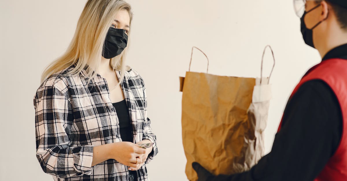 Grocery Delivery Services in Denmark - Young female customer receiving grocery order during coronavirus pandemic