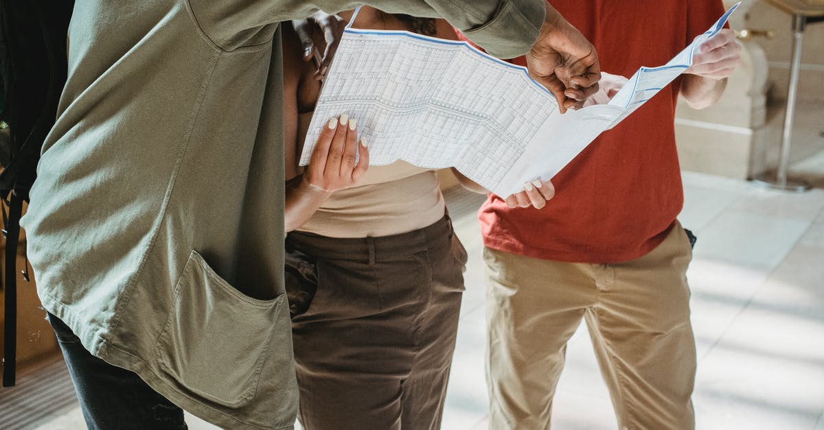 Group Travel with Virtual Guide - Anonymous diverse tourists exploring map during trip