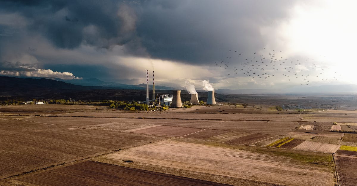 Guided tours of Japanese nuclear power plants - Aerial view of empty fields near atomic power station generating energy and polluting atmosphere