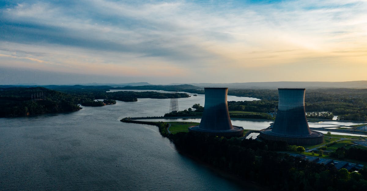 Guided tours of Japanese nuclear power plants - Cooling towers near river under cloudy sky at sundown