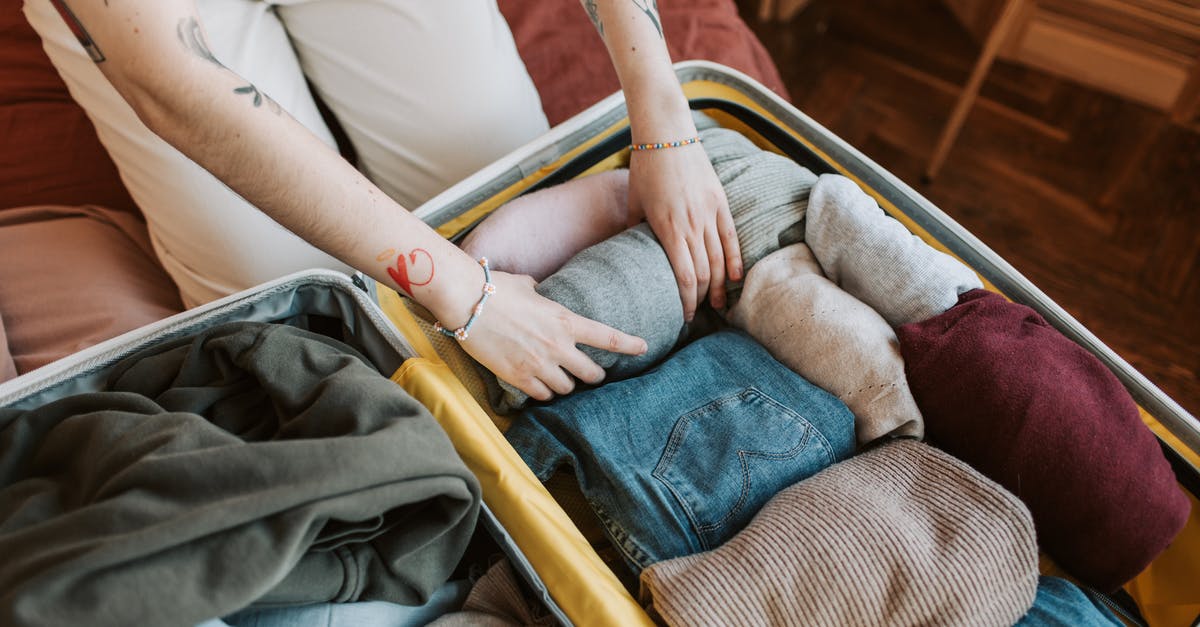 Hand luggage weight? [closed] - Person Packing a Luggage 