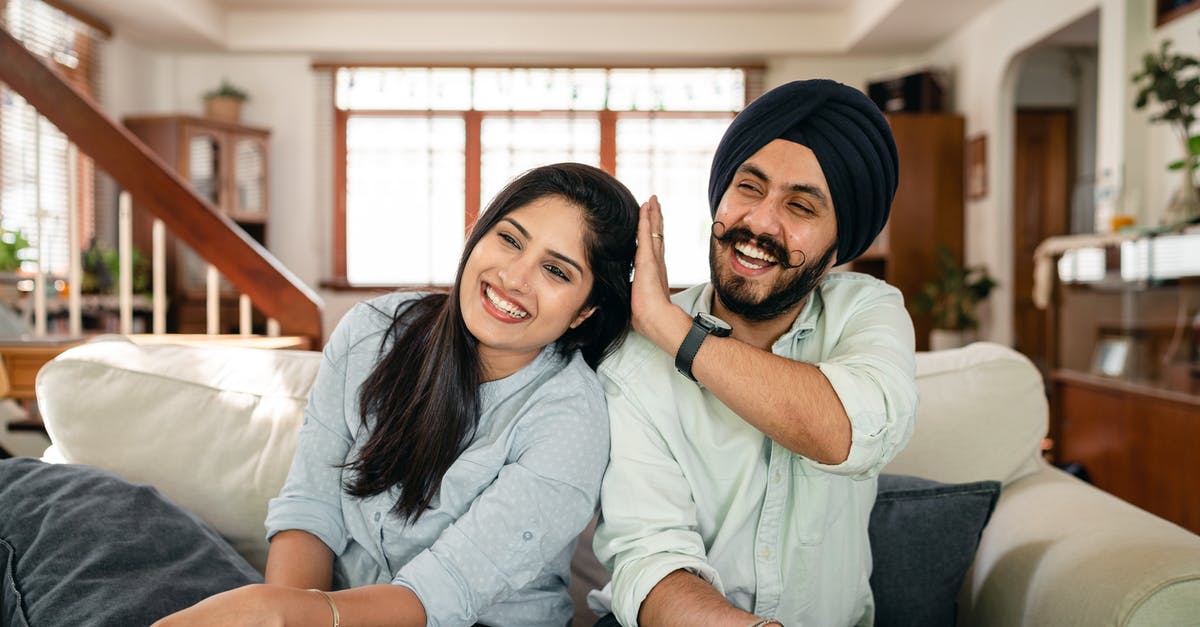 Have I been granted the UK spouse visa? - Playful Indian spouses having fun on sofa during weekend