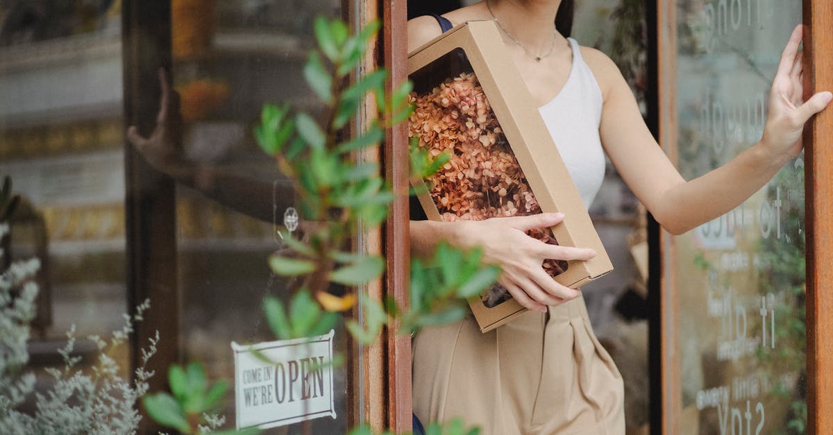 Have I been “Required to leave the UK”? - Crop glad woman with dried flowers box leaving floristry store