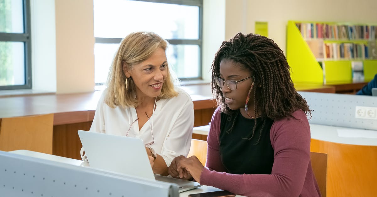 Help with Student Visa (Residence Permit in the EU) and Schengen Visa [duplicate] - Positive adult female teacher explaining task to young black student with Afro braids doing assignment on laptop in modern classroom