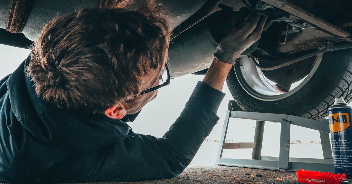 Hiking in Scotland under 21 without a car - Man Fixing Vehicle Engine