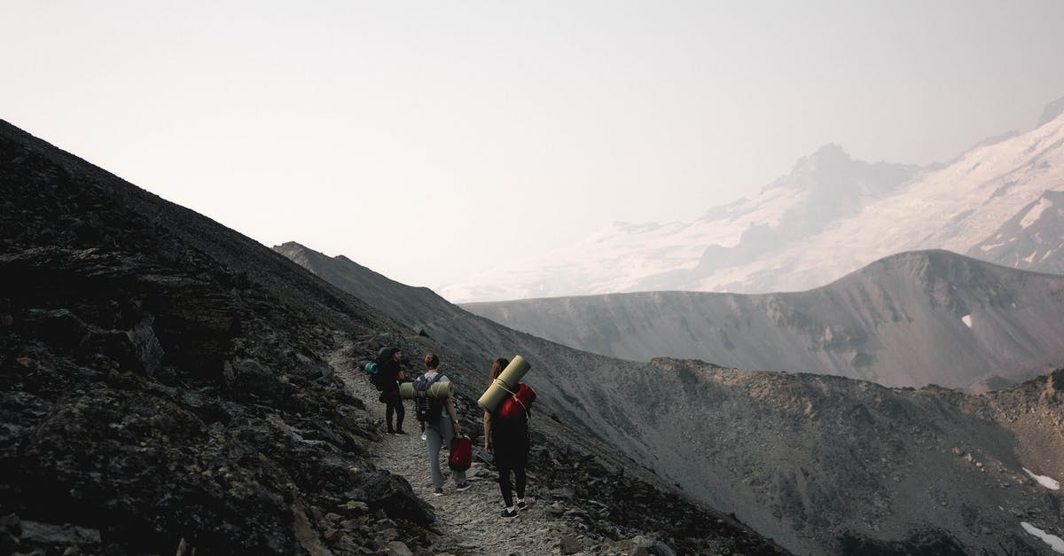 Hiking routes near Embrun - Unrecognizable travelers walking on rocky slope