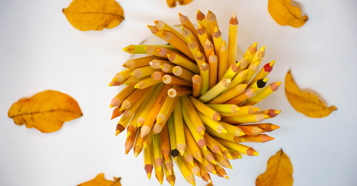 Hiking/nature around Lyon - Top view composition of yellow dry tree leaves arranged around holder with bright yellow pencils on white table