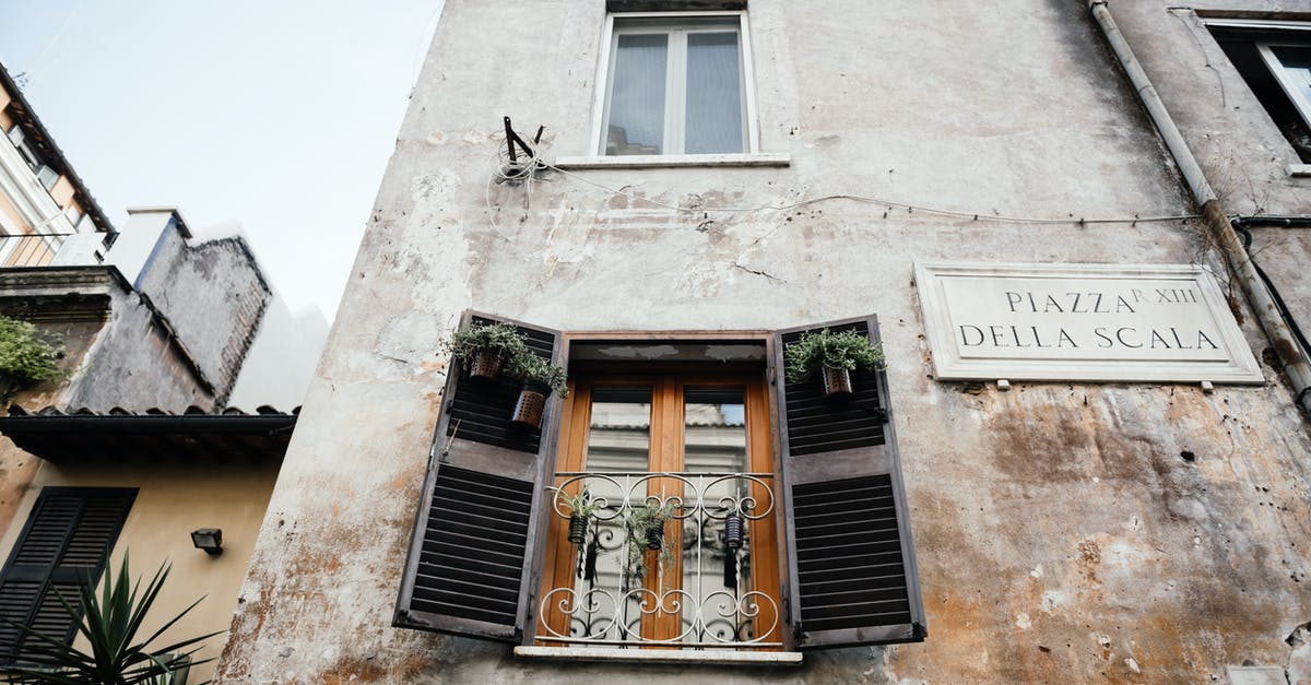 Hiring a Ferrari in Italy - Brown Wooden Window on White Concrete Building