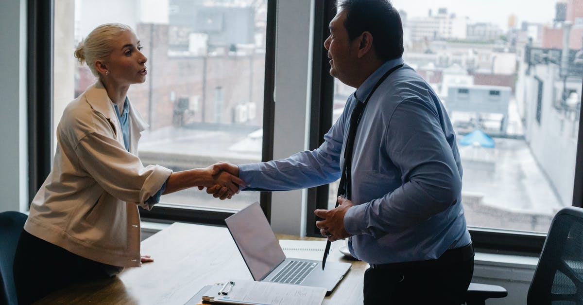 Hiring a solicitor for uk visit visa - Young woman shaking hands with boss after business presentation