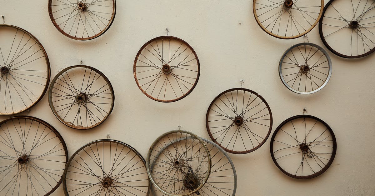 Hiring and buying used bicycle in Tbilisi, Georgia - Different shapes and sizes spoke wheels hanging on light wall