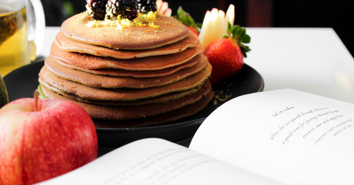 Hitchhike from Montreal to San Francisco - Delicious appetizing pancakes on black plate with blackberries on top and apple near opened book