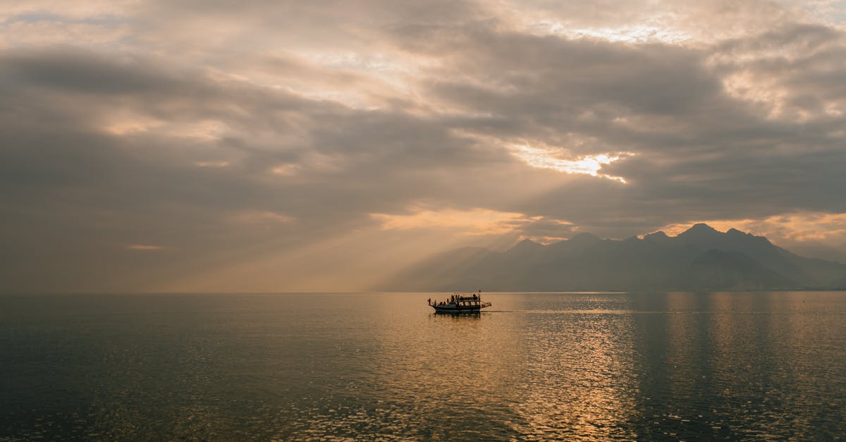 Holiday on Cruise Ship [closed] - Picturesque scenery of boat floating on rippling water of sea against amazing cloudy sunset sky