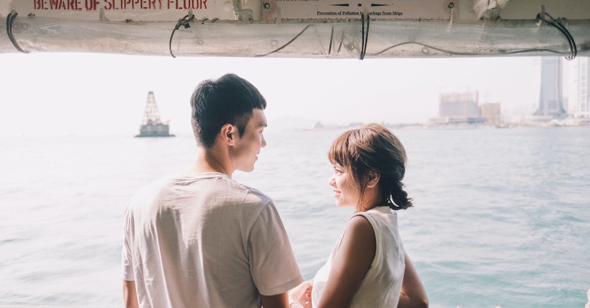 Honeymoon destination options [closed] - Young Asian couple standing on yacht