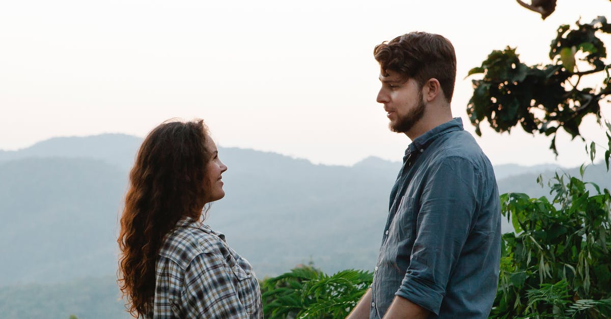 Honeymoon Travel to Italy [closed] - Side view of beloved young man and woman in casual clothes smiling and looking at each other during trip in green highlands