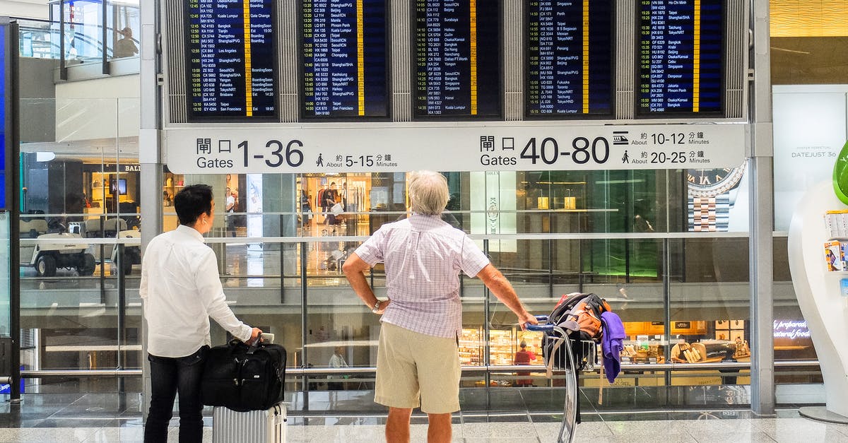 Hong Kong Airport – Macau – Hong Kong - People Looking at Departure Board at an Airport