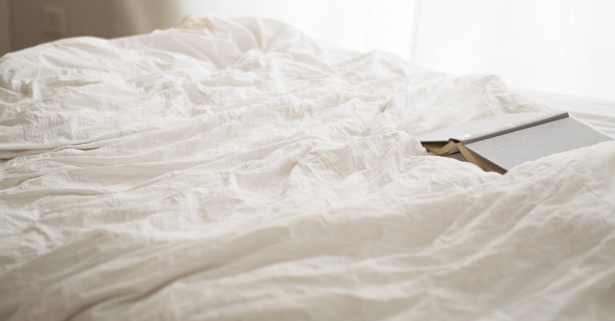 Hotel booking at marriott - Black and Beige Book on White Bed Sheet