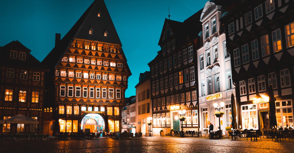 Hotel Reservation for Germany - Outdoor Dinette Set Near Brown Concrete Building at Nighttime