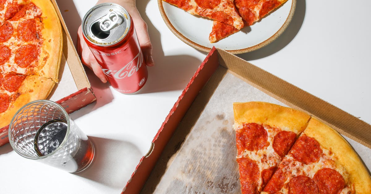 How am I supposed to combine items from Italian restaurant menus? - Person Holding Coca-Cola In Can Beside Pizza on Table