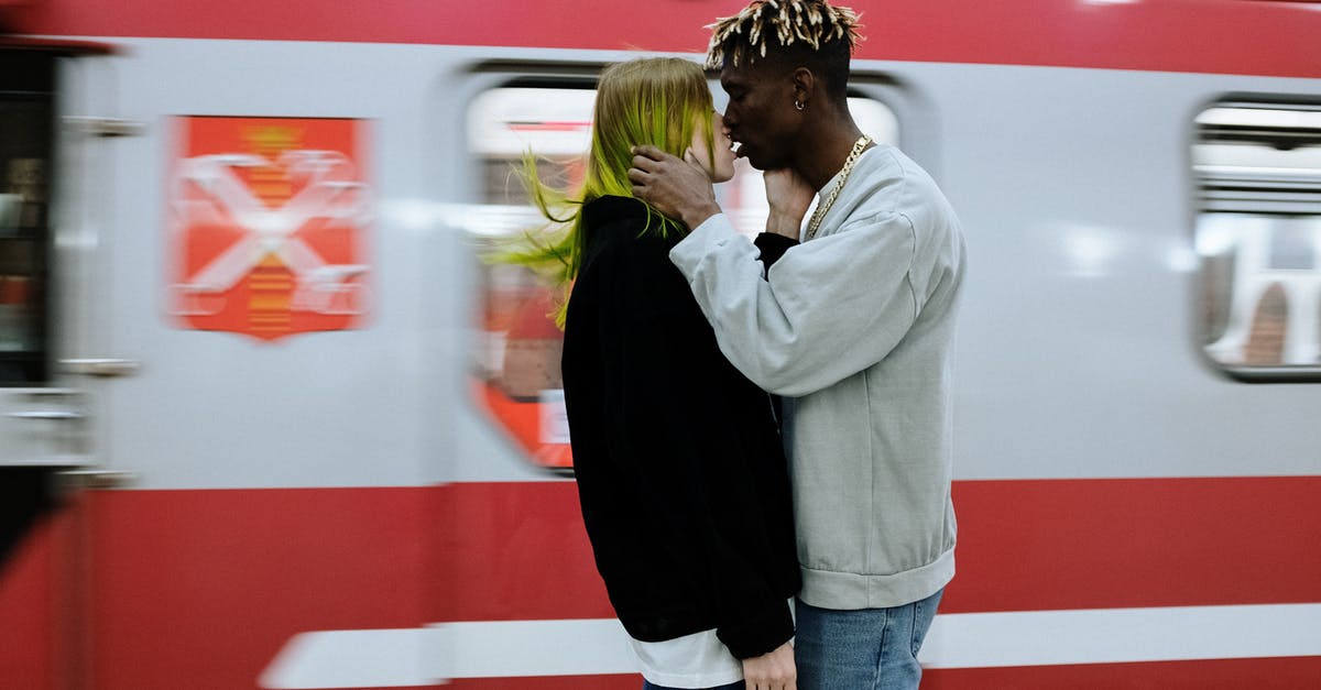 How are the suffixes of railway platforms determined? [closed] - Man in Gray Sweater and Blue Denim Jeans Standing Beside Woman in Black Jacket